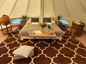 a room with a bed and a table in a tent at Puszcza Glamping in Kuraszewo