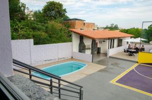 a house with a swimming pool and a basketball court at AP c ESTACIONAMENTO 900m do centro, prédio com piscina, sauna e academia in São João del Rei
