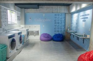 a bathroom with two washing machines and purple bean bags at Studio 900m do centro, prédio com piscina, sauna, academia e lavanderia in São João del Rei