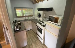 een kleine keuken met een fornuis en een magnetron bij Overflow Cottage in Clarens
