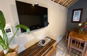 een woonkamer met een grote flatscreen-tv aan de muur bij Overflow Cottage in Clarens
