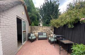 een patio met stoelen, een tafel en een hek bij Overflow Cottage in Clarens