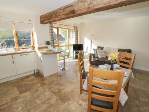 a kitchen and living room with a couch and a table at Granary Cottage in Southam +11 photos