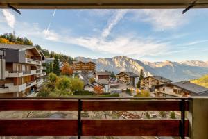 een balkon met uitzicht op een stad met bergen bij Appartement Bellevue 211 in La Tzoumaz
