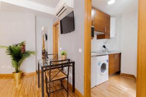 a kitchen with a table and a washing machine in a room at Wonder Apartments in Madrid