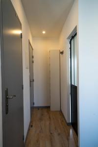 een lege hal met twee deuren en een houten vloer bij La merveille de Rochebonne 2 in Saint-Malo