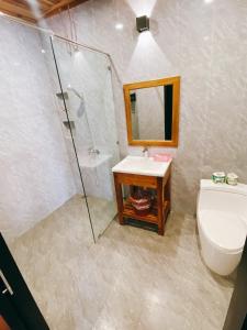 een badkamer met een toilet, een wastafel en een douche bij Opera Premier Hotel in Luang Prabang