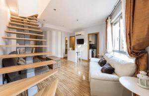 Wonder Apartments في مدريد: غرفة معيشة مع أريكة بيضاء وسلالم خشبية