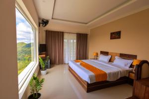 a bedroom with a bed and a large window at The Windy Mist Resort Munnar in Chinnakanal