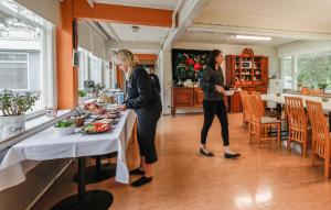 two women are standing at a table with food at Vinsanvilla Bed and Breakfast in Ruovesi