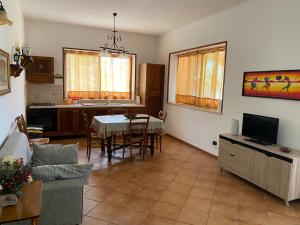 a living room with a table and a kitchen at Villa Piruzzu CV Torre Mulinazzo app P in Cinisi
