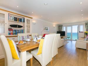 a dining room and living room with a table and chairs at Surf and Sand in St Ives