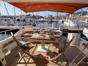 una mesa y sillas en la cubierta de un barco en KARPEDIEM, en Ajaccio