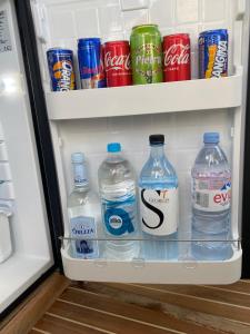 an open refrigerator filled with bottles of water and soda at KARPEDIEM in Ajaccio