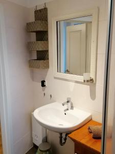 un bagno bianco con lavandino e specchio di AufmLohr - Appartement mit 3 Schlafzimmern- 4 Einzelbetten- für 4 Personen - in Leverkusen Hitdorf - Private Parkplätze vorhanden- a Leverkusen Altre 20 foto