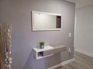 ein Badezimmer mit Waschbecken und Spiegel an der Wand in der Unterkunft Aguamarina Gandia in Playa de Gandia + 19 Fotos