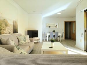 ein Wohnzimmer mit Sofa und Tisch in der Unterkunft Aguamarina Gandia in Playa de Gandia