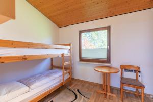 1 Schlafzimmer mit 2 Etagenbetten und einem Tisch in der Unterkunft Yin Yang in Simonsberg