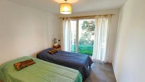 a bedroom with two beds and a large window at Adelina Hue in San Carlos de Bariloche