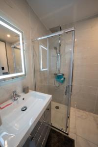 uma casa de banho branca com um chuveiro e um lavatório. em la merveille de Rochebonne 3 em Saint Malo