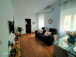 a living room with a black couch and a table at Conde de la Encina in Trujillo