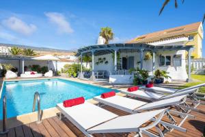 une villa avec une piscine et des chaises longues dans l'établissement Villa Bolsón by W Tenerife, à Puerto de Santiago
