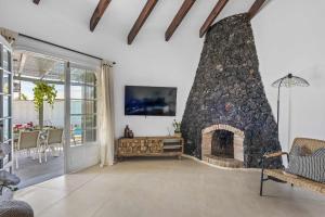 - un salon avec une cheminée en pierre et une télévision dans l'établissement Villa Bolsón by W Tenerife, à Puerto de Santiago