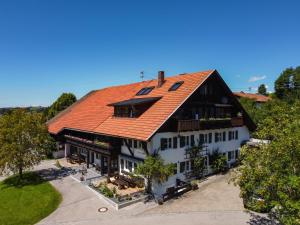 - une vue sur une maison dotée d'un toit orange dans l'établissement Im traditionellen Bauernhaus, à Nesselwang