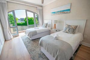 a bedroom with two beds and a large window at Lavender hill in Plettenberg Bay