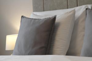 un grupo de almohadas sentado encima de una cama en Hotel Driada, en Gjakove