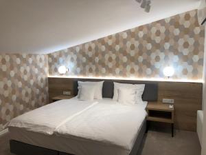 ein Schlafzimmer mit einem großen Bett mit weißer Bettwäsche in der Unterkunft Ermine Suites in Krakau
