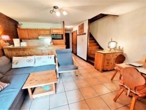 ein Wohnzimmer mit einem Sofa und einem Tisch sowie eine Küche in der Unterkunft Appartement Samoëns, 3 pièces, 6 personnes - FR-1-624-111 in Samoëns