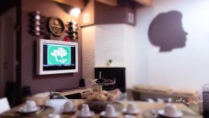 een kamer met een tafel en een televisie aan de muur bij L' Ulivo Bed & Breakfast in Teramo