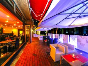 un ristorante con tavoli, sedie e ombrelloni di Kurume Hotel Esprit a Kurume