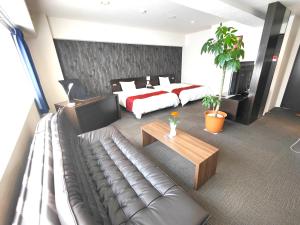 a hotel room with a couch and a bed at Kurume Hotel Esprit in Kurume