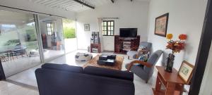 a living room with a couch and a tv at Finca Acogedora - Lago Calima in Calima