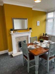 a dining room with a table and a fireplace at Incredible house for Work teams & Holiday stays in Cleethorpes