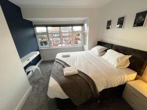 a bedroom with a large bed and a window at Incredible house for Work teams & Holiday stays in Cleethorpes