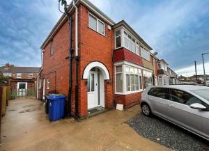 a car parked in front of a brick house at Incredible house for Work teams & Holiday stays in Cleethorpes