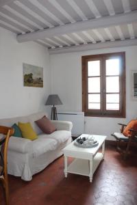 ein Wohnzimmer mit einem weißen Sofa und einem Tisch in der Unterkunft Duplex- Isle sur Sorgue in LʼIsle-sur-la-Sorgue