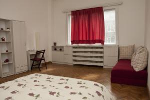 - un salon avec un lit et un rideau rouge dans l'établissement Hostel Mostel Sofia, à Sofia