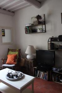 ein Wohnzimmer mit einem TV und einem Couchtisch in der Unterkunft Duplex- Isle sur Sorgue in LʼIsle-sur-la-Sorgue