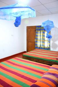 1 dormitorio con 2 camas y alfombra colorida en Dula Lake Resort, en Anuradhapura