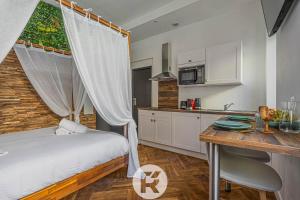 a bedroom with a bed and a desk and a kitchen at MYD - Studio Cocooning Végétal in Grenoble