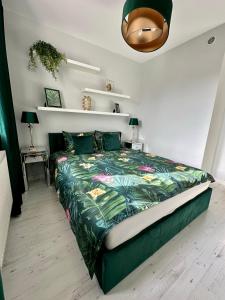 um quarto com uma cama com um edredão verde em LuxApart Kalisz New em Kalisz