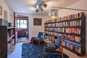 a library with two chairs and book shelves filled with books at Exklusives und Modernes Bauernhaus in Nesselwang