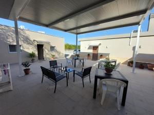 a patio with tables and chairs and a patio umbrella at La Collinetta Dei Sassi in Matera