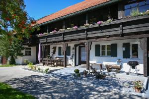 a house with a courtyard with a table and a grill at Exklusives und Modernes Bauernhaus in Nesselwang