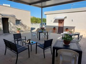 a patio with tables and chairs and a building at La Collinetta Dei Sassi in Matera