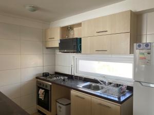 a kitchen with a sink and a stove and a window at Playa Herradura in Coquimbo